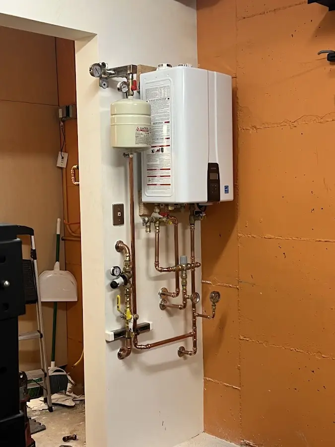 Plumbing technician inspecting water heater connections in Breckenridge